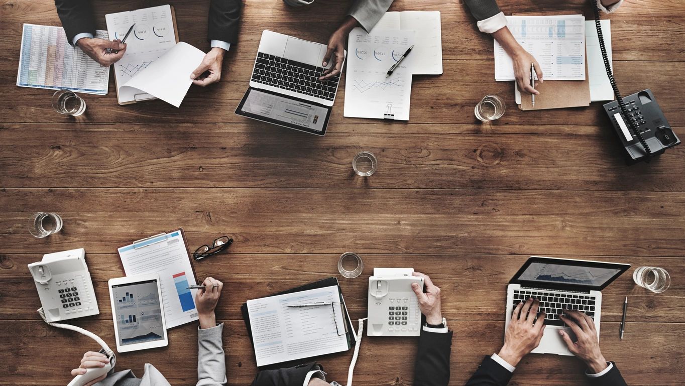 Top view of some workers along with a laptop on the table