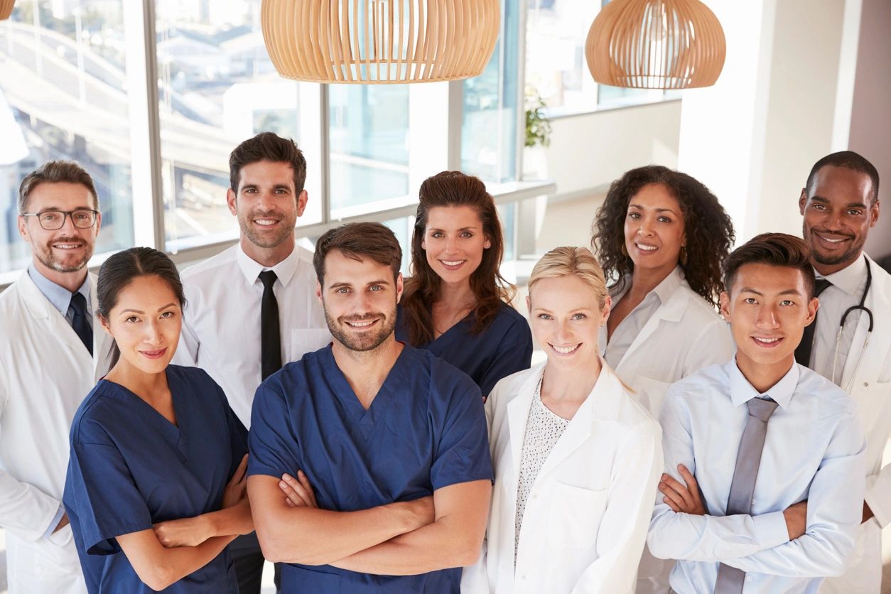 Some doctors along with coworkers smiling at the camera